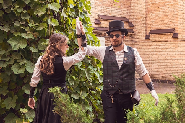 Hermosa chica con una pareja de chicos enamorados con ropa steampunk