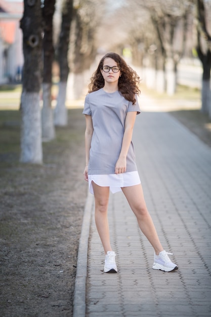 Hermosa chica en el parque al aire libre, posando mirando a la cámara