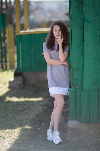 Hermosa chica en el parque al aire libre, posando mirando a la cámara