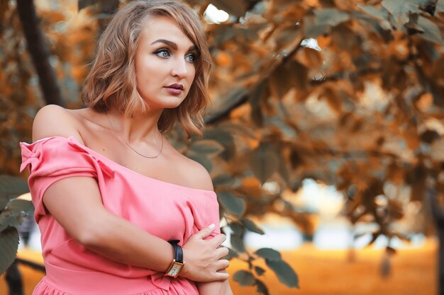 Hermosa chica en el parque en un día soleado de otoño a pie