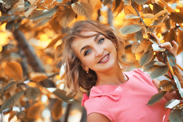 Hermosa chica en el parque en un día soleado de otoño a pie