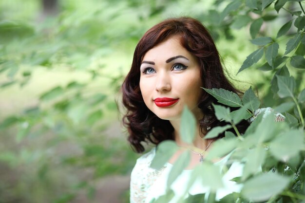 Hermosa chica en un parque de hojas de primavera