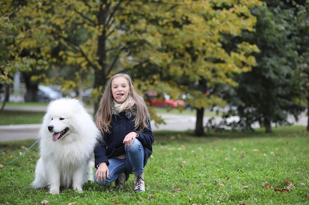 Hermosa chica en un paseo con un hermoso perro