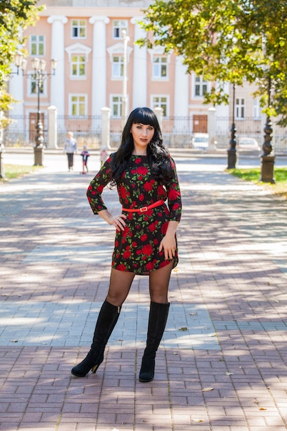 Hermosa chica en un paseo con el telón de fondo de la arquitectura de la ciudad.