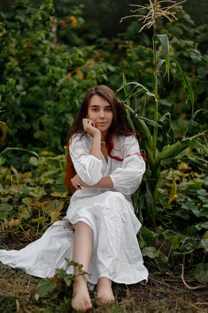 Hermosa chica pelirroja con un vestido blanco al aire libre en un día soleado