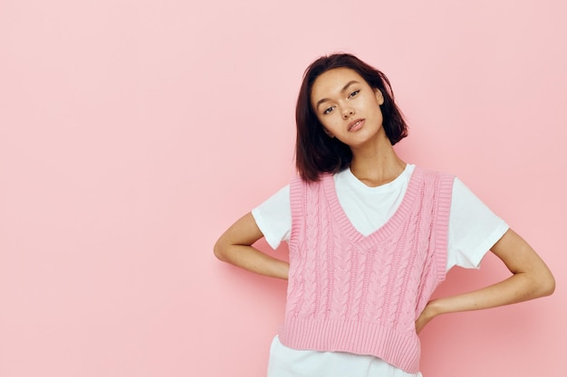 Hermosa chica con el pelo corto y un suéter rosa de fondo aislado