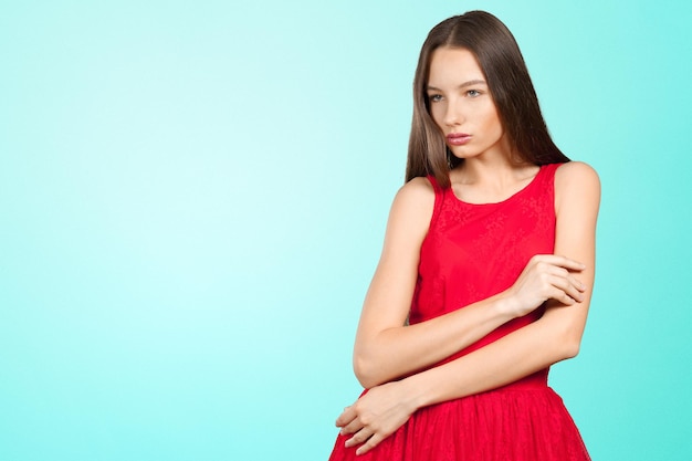 Hermosa chica con el pelo largo y castaño en vestido rojo.