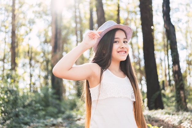 Una hermosa chica de pelo largo con sombrero al aire libre.