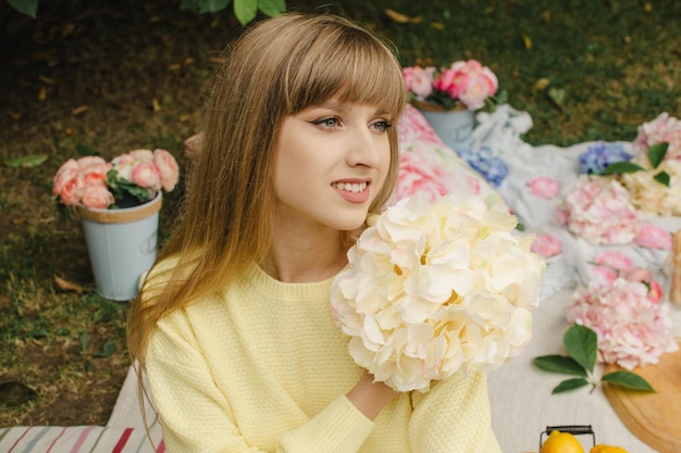 Hermosa chica en un picnic con flores.