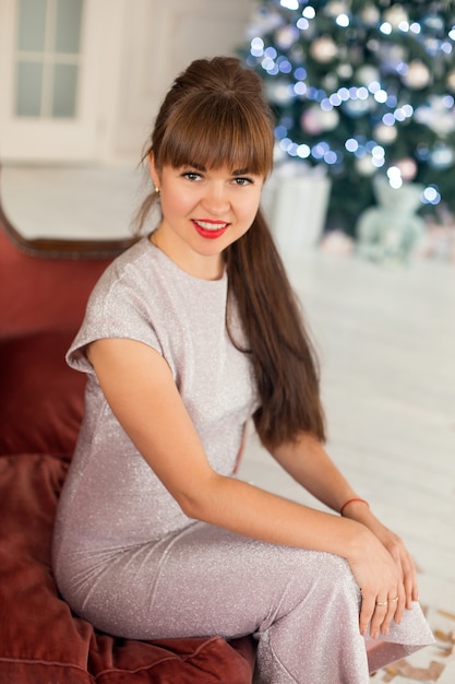 Foto hermosa chica posando en adornos navideños. emocionado por las vacaciones de invierno.