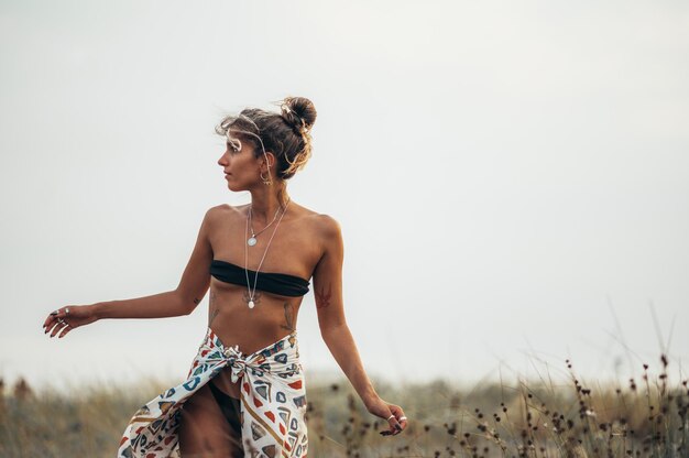 Hermosa chica posando afuera en un día cálido y ventoso