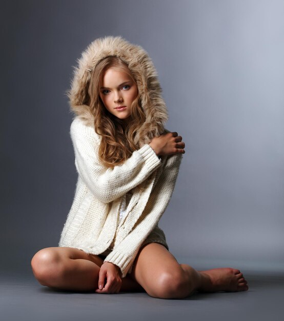Una hermosa chica posando con una chaqueta de lana con capucha