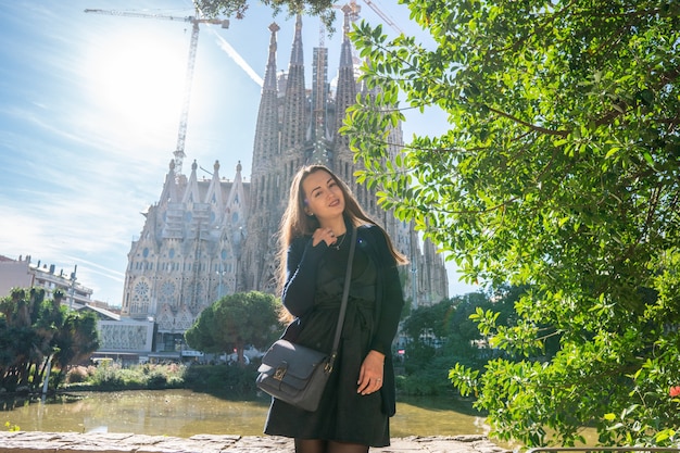 Hermosa chica posando detrás de una increíble iglesia gótica en Europa