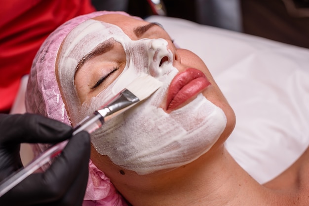 Hermosa chica en un procedimiento de cosmetología relajante