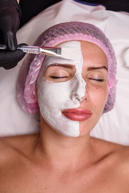 Hermosa chica en un procedimiento de cosmetología relajante