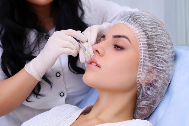 Hermosa chica en procedimiento de rejuvenecimiento en inyección de relleno de clínica de belleza