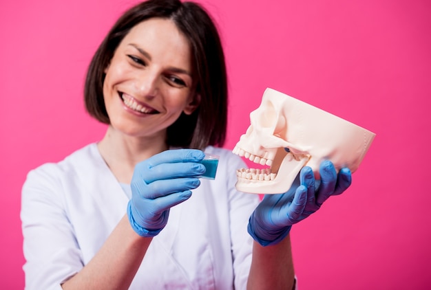 Hermosa chica propone enjuague bucal para cráneo artificial