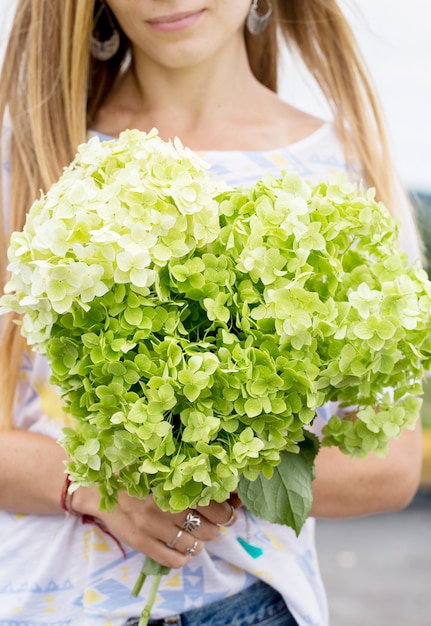 Hermosa chica con un ramo de hortensias