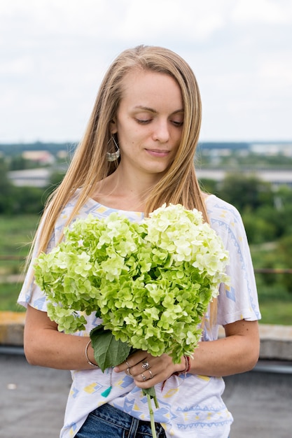 Hermosa chica con un ramo de hortensias