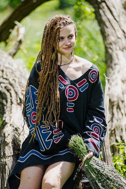 Foto hermosa chica con rastas vestida estilo hippie posa al aire libre