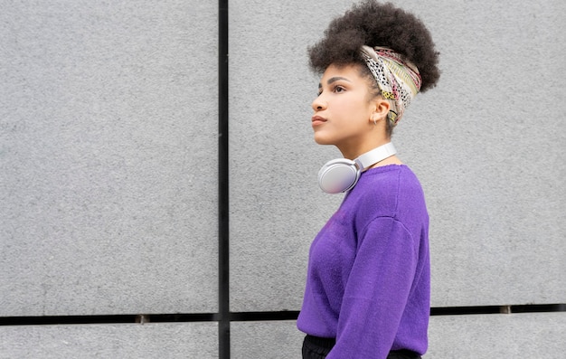 Hermosa chica de raza mixta con cabello afro escuchando su música favorita