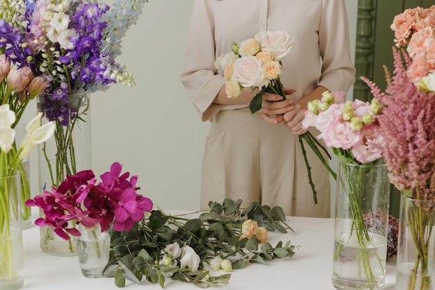 Hermosa chica recoge un ramo de flores en una floristería