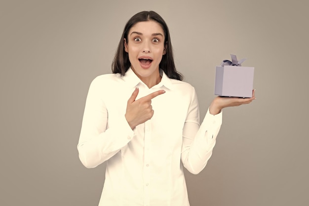 Hermosa chica con regalo de San Valentín Expresiones faciales expresivas con cara sorprendida Feliz cumpleaños celebración día de la mujer Navidad Mujer con caja de regalo y se regocija