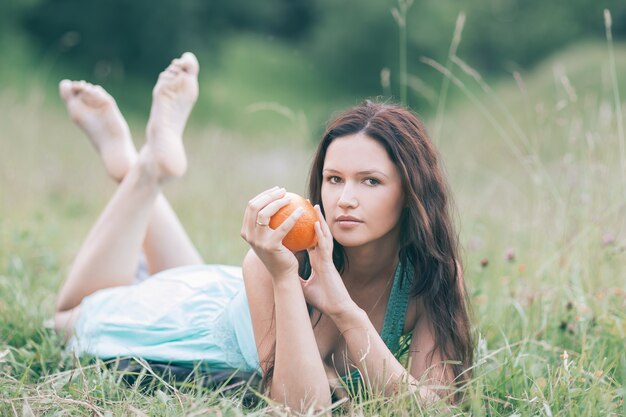 Hermosa chica relajándose en el césped en un día de verano