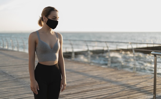 Hermosa chica en un respirador médico junto al mar