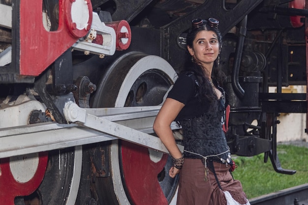 Hermosa chica con ropa steampunk en el fondo del tren