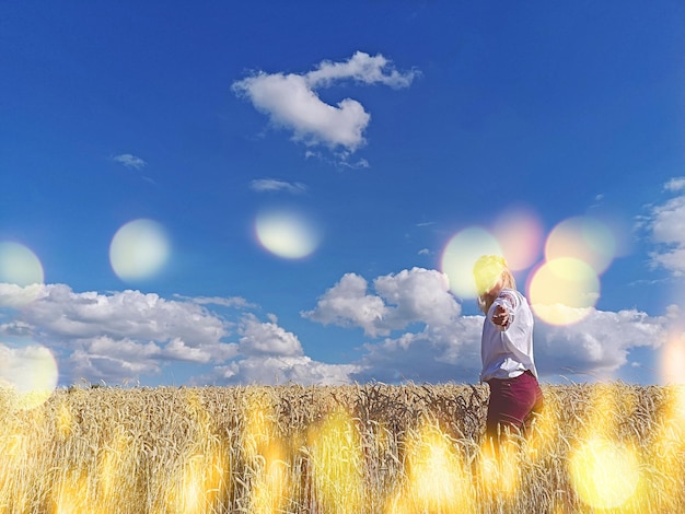 Hermosa chica con ropa tradicional ucraniana en un campo de trigo Hermosa chica con una camisa bordada en un campo de trigo al atardecer