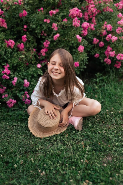 Foto hermosa chica entre rosas rosadas afuera