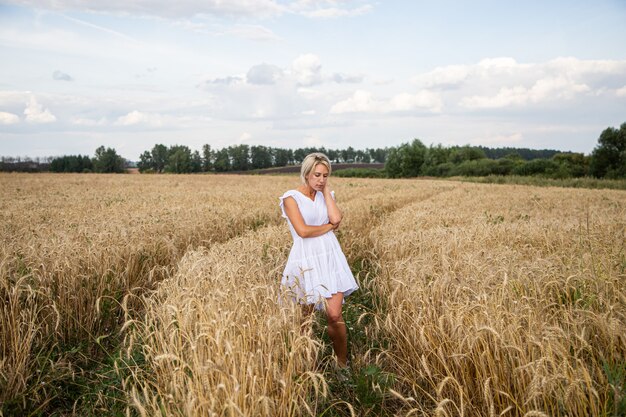 Hermosa chica rubia en un campo de trigo