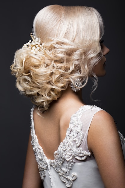 Hermosa chica rubia en la imagen de la novia con accesorios de boda en la cabeza. Cara de belleza