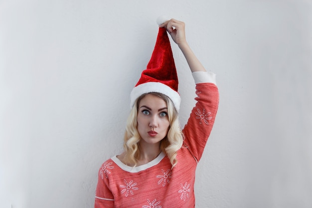 Hermosa chica rubia con sombrero de Navidad divertirse.