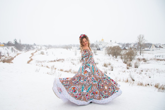 Hermosa chica rusa en un vestido nacional de invierno