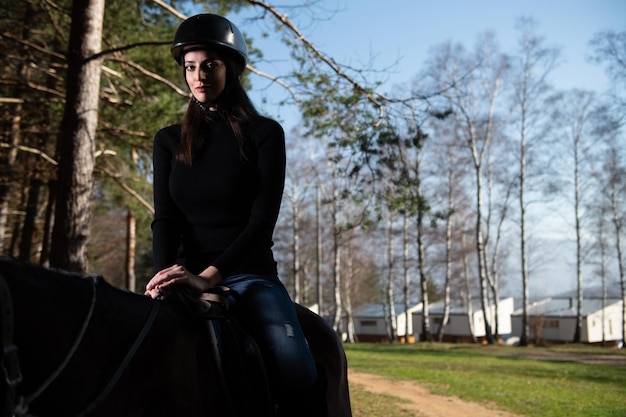 Hermosa chica sentada sobre un caballo al aire libre