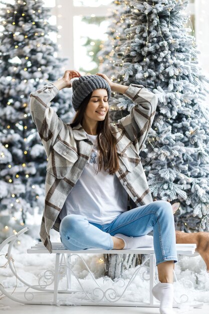 Una hermosa chica en una sesión de fotos de Año Nuevo en el estudio El concepto de Año Nuevo Estilo de cabello largo y maquillaje Mujer atractiva joven en un interior de lujo