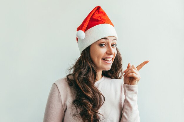 Hermosa chica en sombrero rojo de Santa Claus aislado