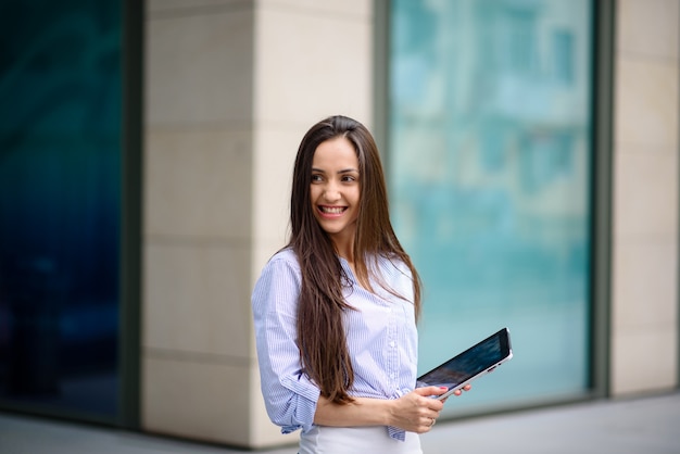 Hermosa chica sonriendo y corriendo en una tableta.