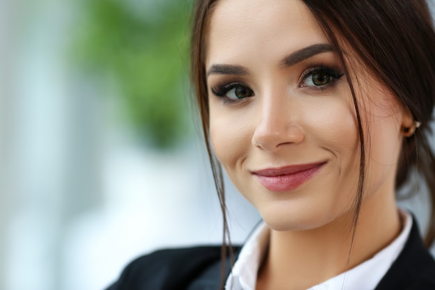 Hermosa chica sonriente empleado vistiendo traje sostenga cuaderno