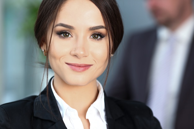 Foto hermosa chica sonriente empleado vistiendo traje sostenga cuaderno