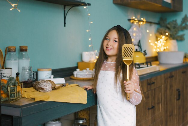 Hermosa chica sosteniendo una espátula de cocina