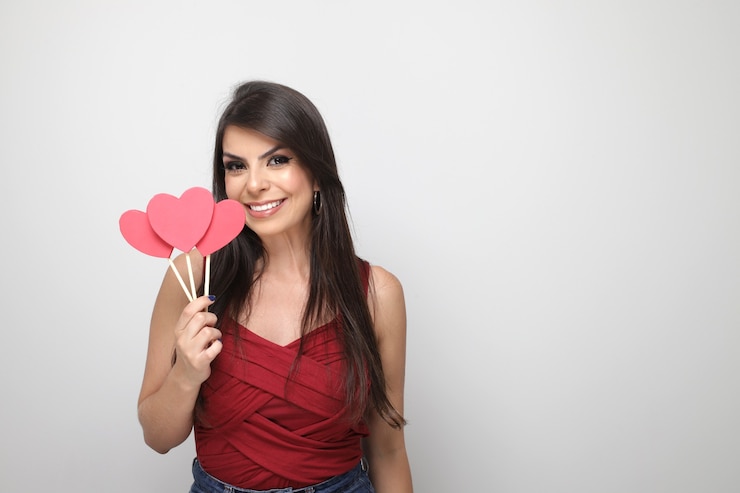 Foto hermosa chica sosteniendo el regalo de san valentín sobre fondo blanco.