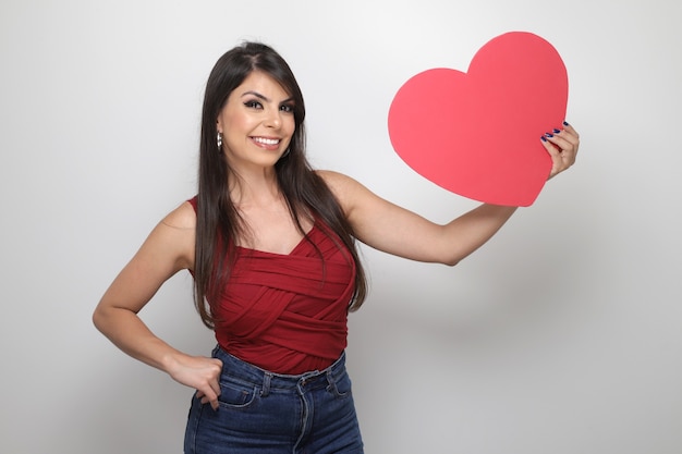 Hermosa chica sosteniendo el regalo de San Valentín sobre fondo blanco.