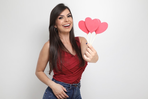 Hermosa chica sosteniendo el regalo de San Valentín sobre fondo blanco.