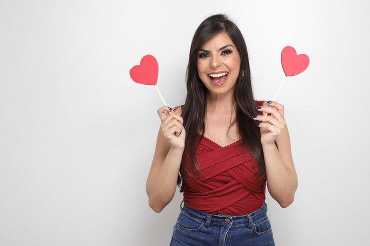Foto hermosa chica sosteniendo el regalo de san valentín sobre fondo blanco.