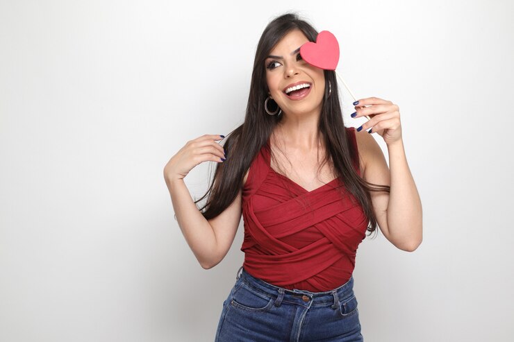 Foto hermosa chica sosteniendo el regalo de san valentín sobre fondo blanco.