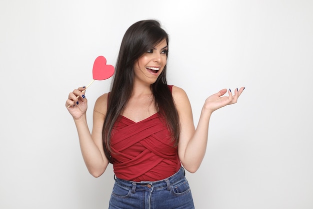 Hermosa chica sosteniendo el regalo de San Valentín sobre fondo blanco.