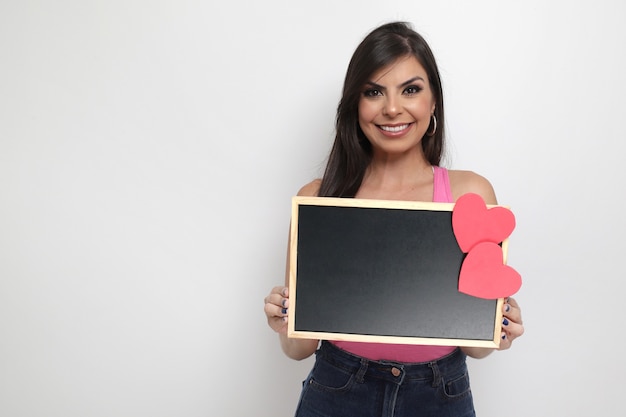 Hermosa chica sosteniendo el regalo de San Valentín sobre fondo blanco.